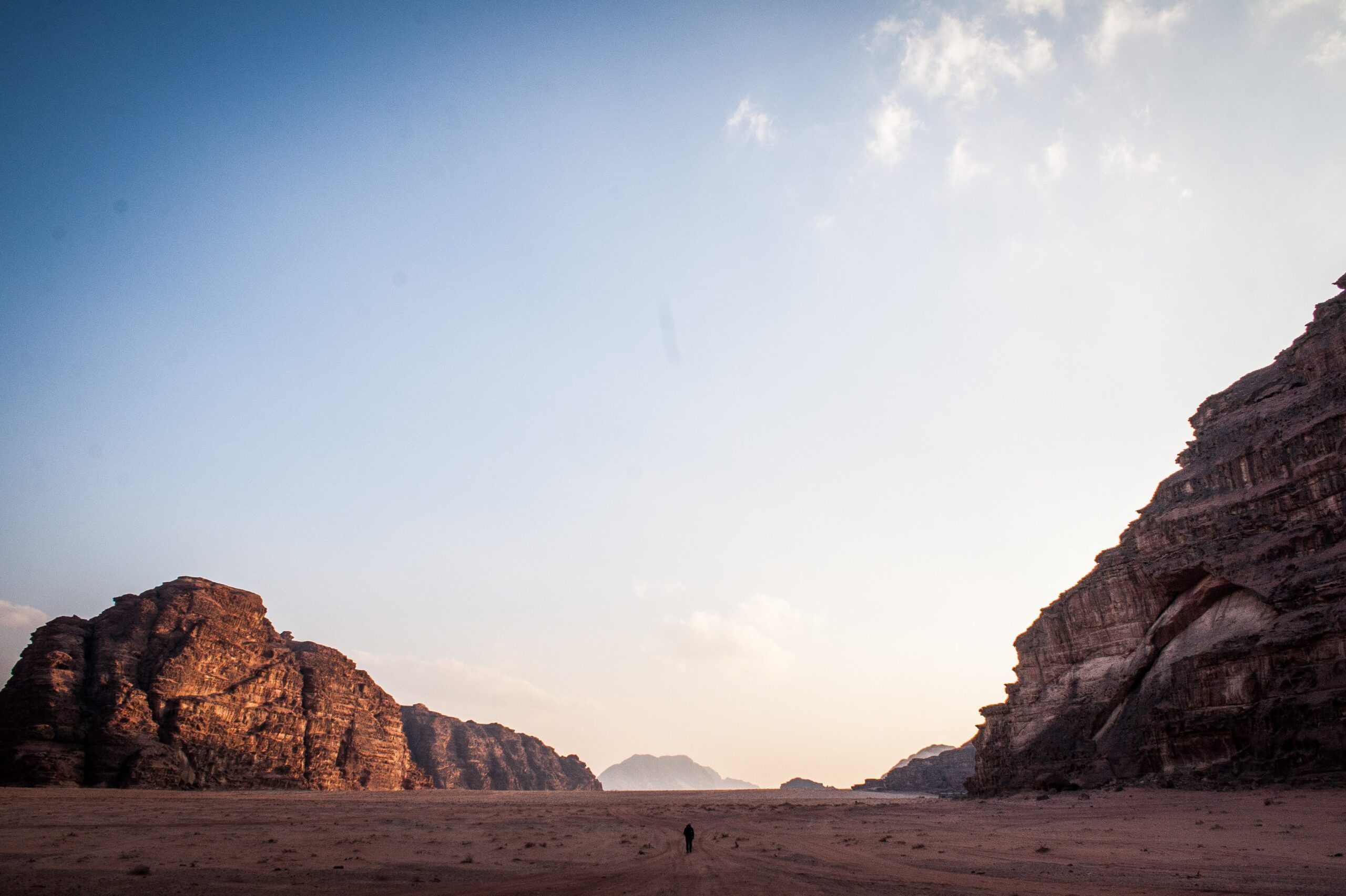 Bezkresna przestrzeń pustyni Wadi Rum w Jordanii z samotną postacią
