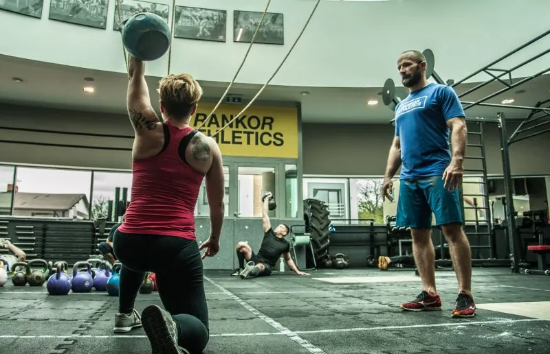 Trener objaśnia klubowiczowi ćwiczenie podczas treningu w Rankor Athletics